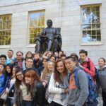 Students in fron tof a statue in harvard square