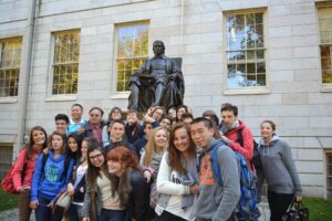 Students in fron tof a statue in harvard square