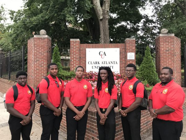 Students in front of a university sign at Clark